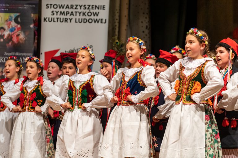 Na zdjęciu grupa młodzieży w strojach krakowskich. Śpiewają.