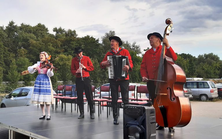 na zdjęciu czterech muzyków ubranych w stroje regionalne grających na scenie