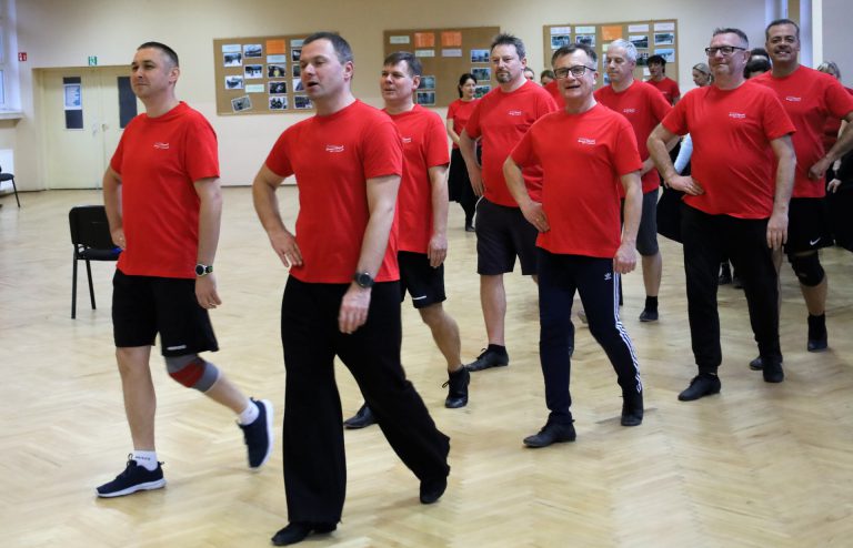 na zdjęciu tańczący mężczyźni ubrani w stroje ćwiczebne