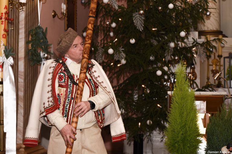 na zdjęciu mężczyzna ubrany w strój regionalny grający na instrumencie tradycyjnym