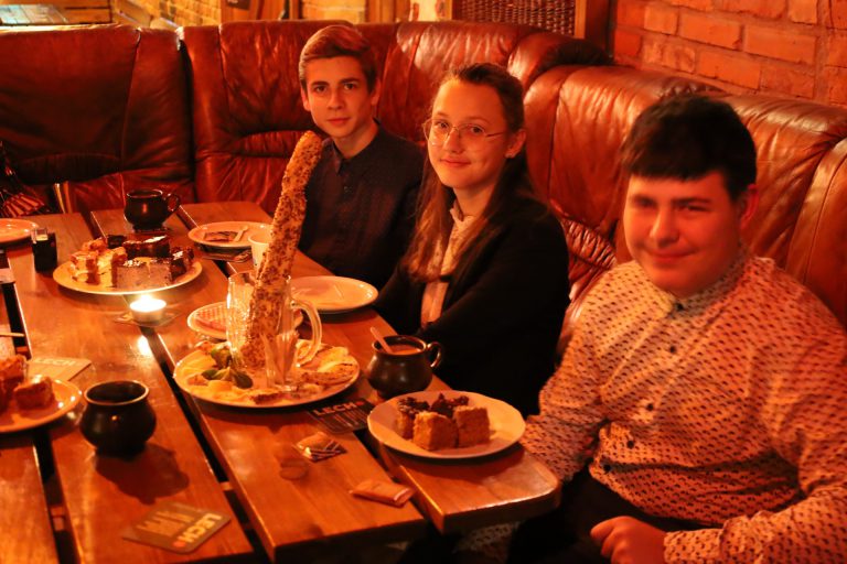 na zdjęciu młodzież siedząca przy stole
