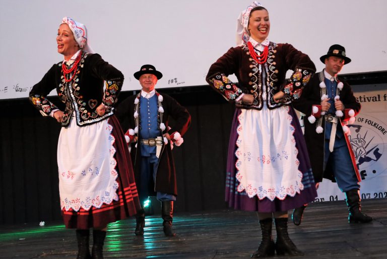 na zdjęciu grupa osób ubrana w struje regionalne tańcząca na scenie