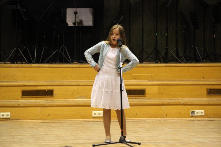 Na zdjęciu młoda dziewczyna na scenie