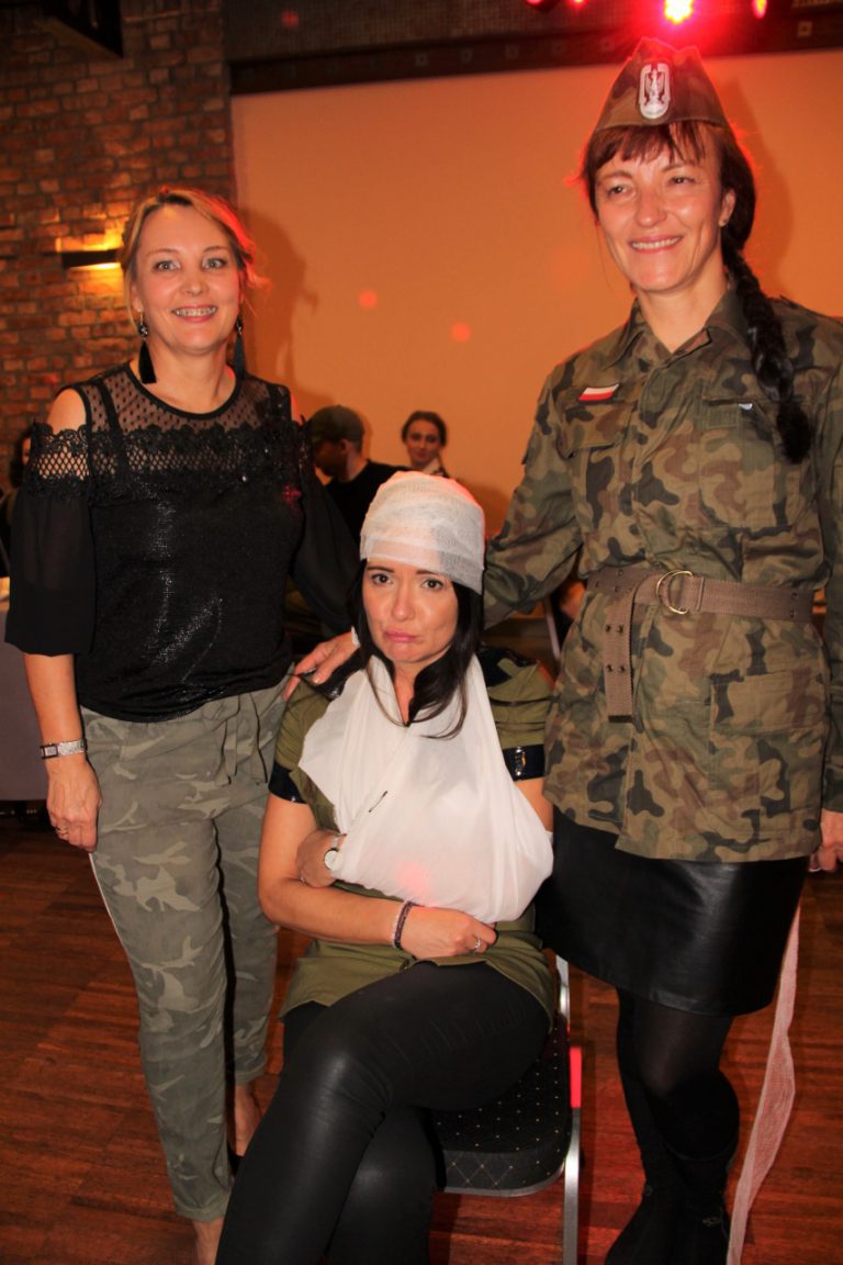 Na zdjęciu trzy kobiety w strojach wojskowych. Dwie stoją