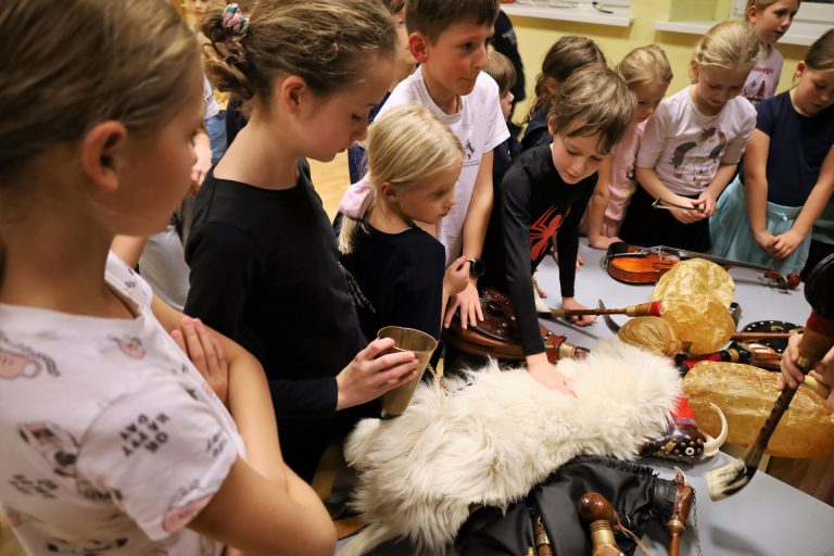 na zdjęciu dzieci oglądające wielkopolskie instrumenty tradycyjne