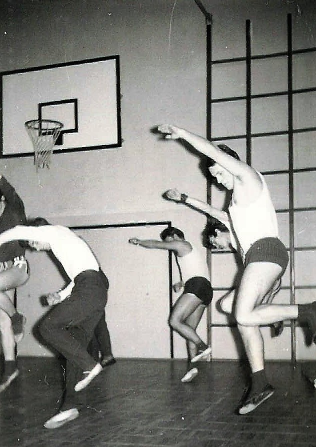 Tancerze ćwiczący tańce ludowe na sali gimnastycznej.
